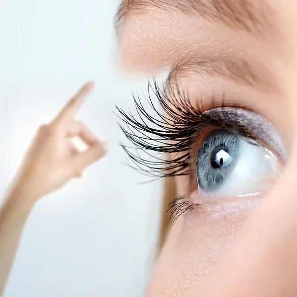 Close-up van een oog dat een wijzende vinger volgt